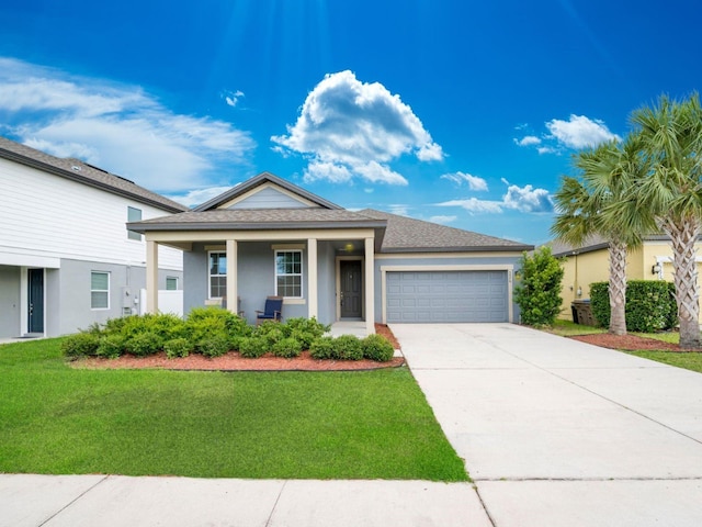 ranch-style home featuring an attached garage, stucco siding, a front lawn, driveway, and covered porch