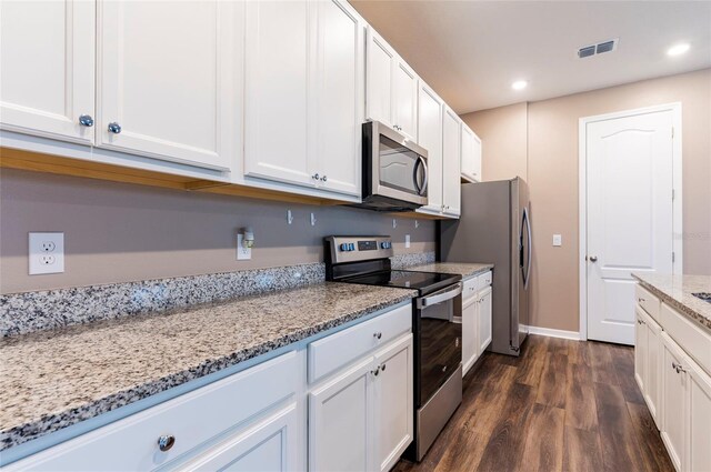 kitchen featuring appliances with stainless steel finishes, dark wood finished floors, light stone counters, recessed lighting, and white cabinets