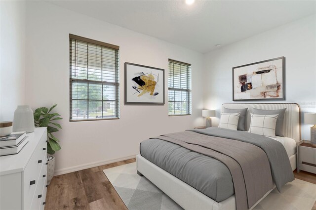 bedroom featuring light wood finished floors and baseboards