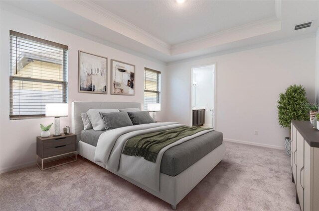 bedroom with crown molding, light carpet, a raised ceiling, baseboards, and connected bathroom