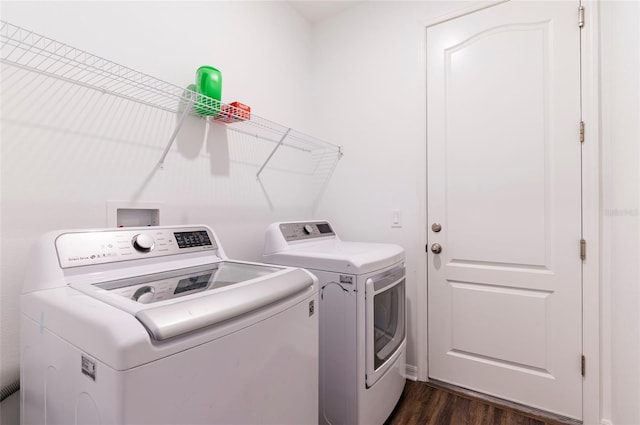 laundry room featuring washer and dryer and dark wood-type flooring