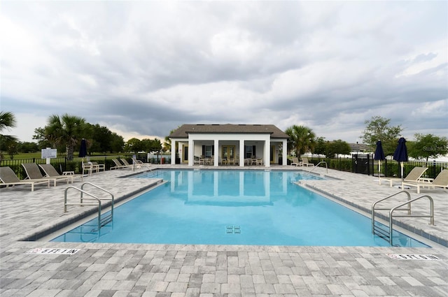 community pool featuring fence and a patio area
