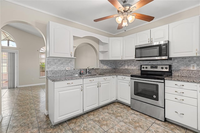 kitchen with stainless steel appliances, a sink, stone counters, tasteful backsplash, and crown molding