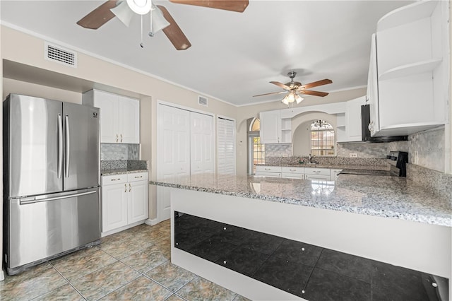 kitchen featuring stainless steel appliances, open shelves, a ceiling fan, a peninsula, and arched walkways