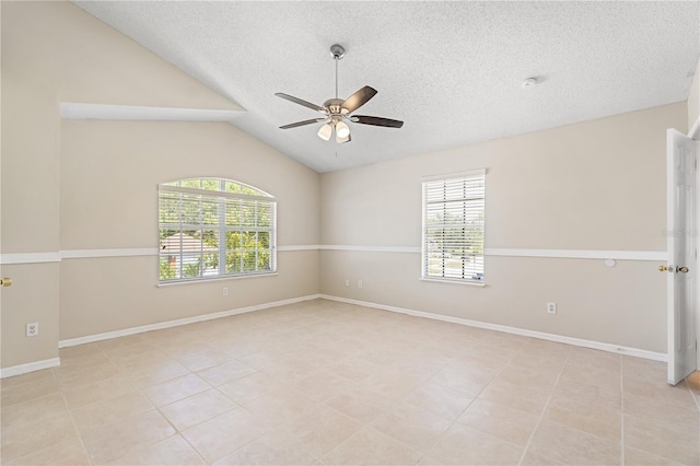 tiled empty room with ceiling fan, a textured ceiling, lofted ceiling, and baseboards