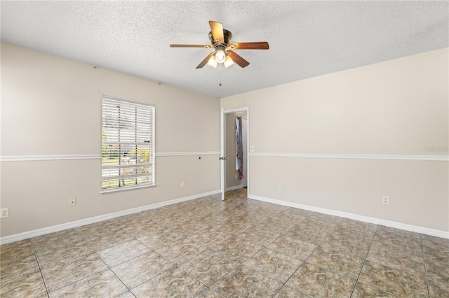 unfurnished room with a textured ceiling, ceiling fan, tile patterned flooring, and baseboards