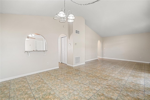 unfurnished living room with arched walkways, tile patterned floors, a chandelier, ceiling fan, and baseboards