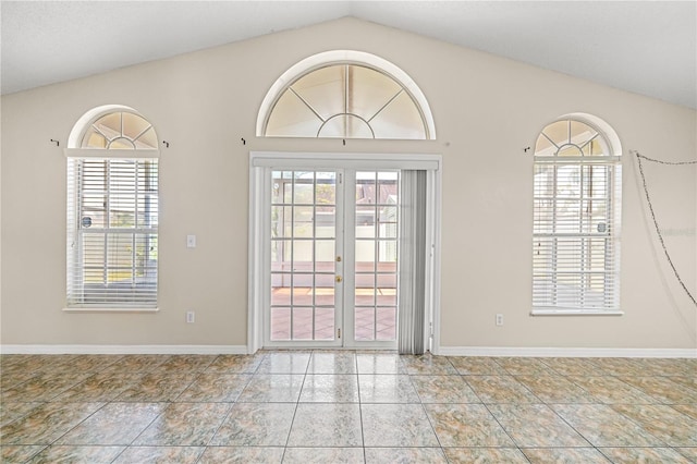 spare room with vaulted ceiling, french doors, and baseboards