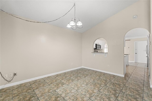 tiled empty room with a chandelier, vaulted ceiling, arched walkways, and baseboards