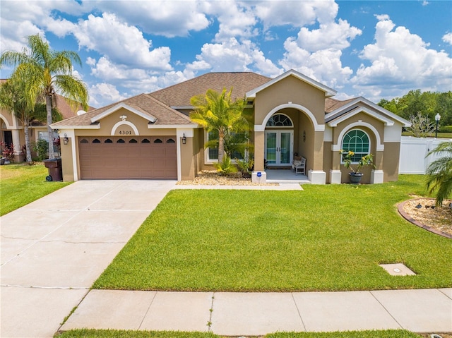 mediterranean / spanish home with french doors, stucco siding, an attached garage, and concrete driveway