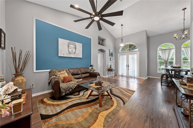 living room featuring arched walkways, french doors, a ceiling fan, wood finished floors, and baseboards