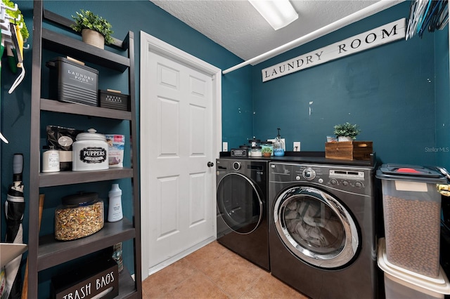 laundry area with washer and dryer, tile patterned floors, and a textured ceiling