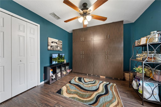 bedroom featuring wood finished floors, a textured ceiling, ceiling fan, and baseboards