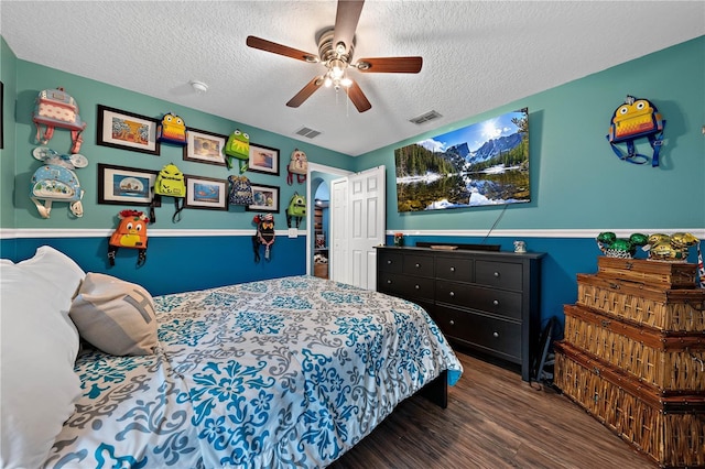bedroom featuring a textured ceiling, wood finished floors, and a ceiling fan