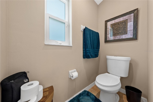 bathroom with baseboards, toilet, and tile patterned flooring