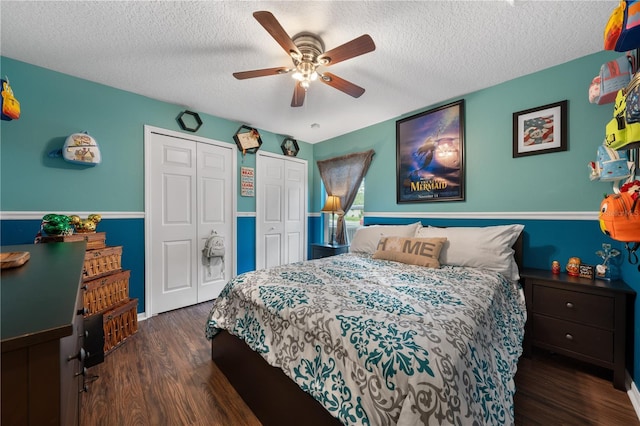 bedroom with multiple closets, a textured ceiling, wood finished floors, and ceiling fan