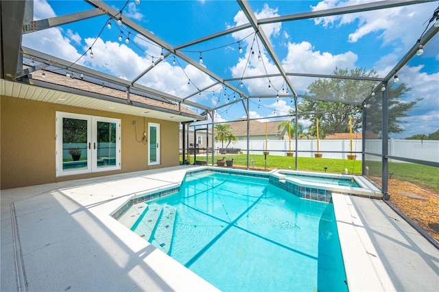 view of swimming pool featuring a patio area, fence, a pool with connected hot tub, and glass enclosure
