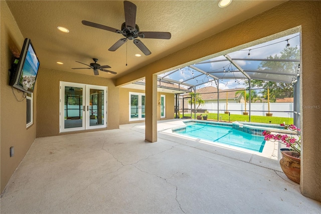 view of pool featuring french doors, a patio area, a ceiling fan, and a pool with connected hot tub