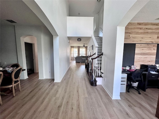 2691 Cypress Tree Trl, Saint Cloud, FL 34772 - foyer entrance featuring arched walkways, stairs, wood finished floors, baseboards, and a high ceiling