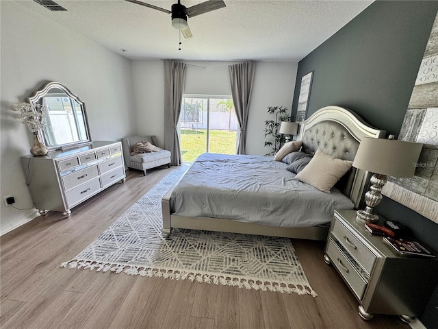 2691 Cypress Tree Trl, Saint Cloud, FL 34772 - bedroom featuring multiple windows, wood finished floors, a textured ceiling, and ceiling fan