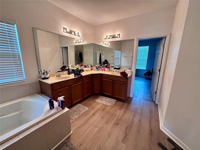 2691 Cypress Tree Trl, Saint Cloud, FL 34772 - full bath with double vanity, a bath, and wood finished floors
