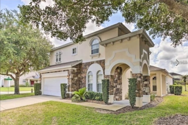 214 Tupelo Cir, Davenport, FL 33897 - mediterranean / spanish house with an attached garage, stone siding, concrete driveway, stucco siding, and a front lawn