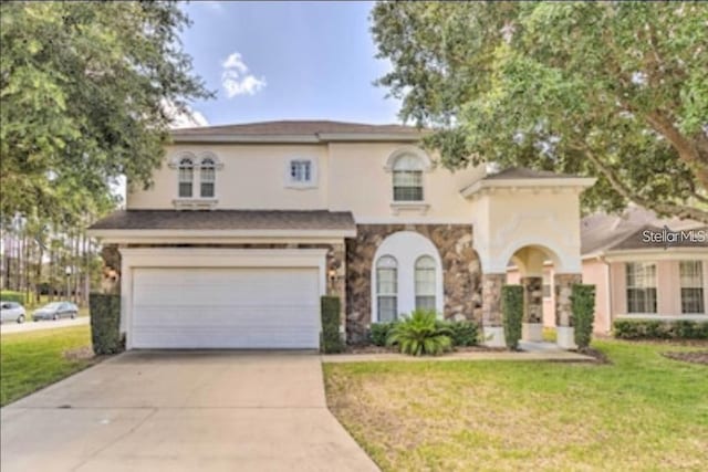 214 Tupelo Cir, Davenport, FL 33897 - view of front of house featuring driveway, stucco siding, a front lawn, an attached garage, and stone siding