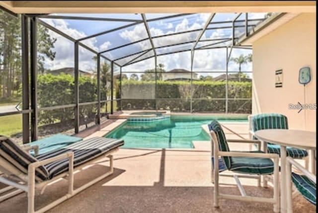214 Tupelo Cir, Davenport, FL 33897 - view of swimming pool with glass enclosure, a patio, and a pool with connected hot tub