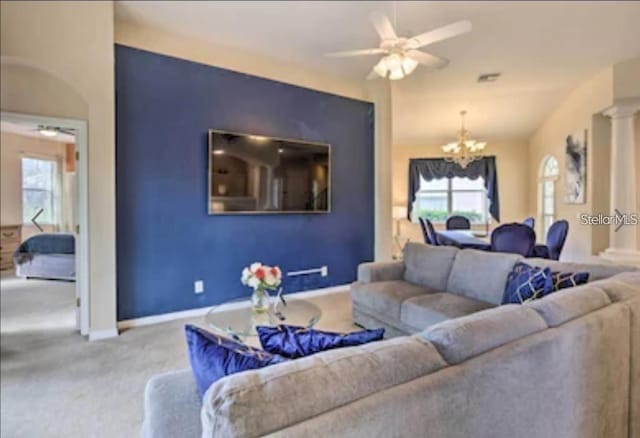 214 Tupelo Cir, Davenport, FL 33897 - carpeted living room with a chandelier, ceiling fan, baseboards, and ornate columns