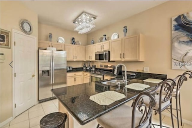 214 Tupelo Cir, Davenport, FL 33897 - kitchen with stainless steel appliances, light brown cabinetry, a peninsula, and a breakfast bar area