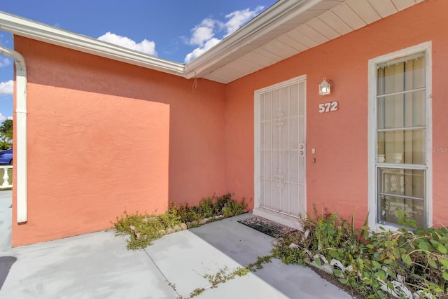572 Floral Dr, Kissimmee, FL 34743 - entrance to property with stucco siding and a patio area