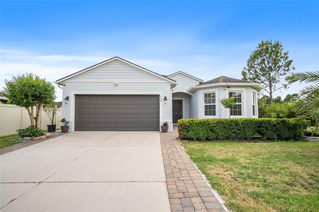1688 Tamarind Rd, Davenport, FL 33896 - ranch-style house featuring an attached garage, concrete driveway, and stucco siding