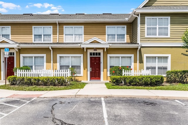 4551 Jonafree Ln Unit 103, Kissimmee, FL 34746 - townhome / multi-family property with uncovered parking, fence, and stucco siding
