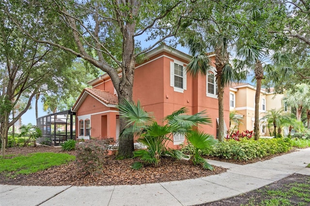 3015 Yellow Lantana Ln, Kissimmee, FL 34747 - view of front of home with stucco siding, a tiled roof, and glass enclosure
