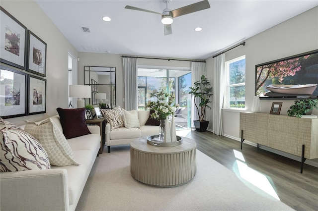living area featuring wood finished floors, ceiling fan, recessed lighting, and baseboards