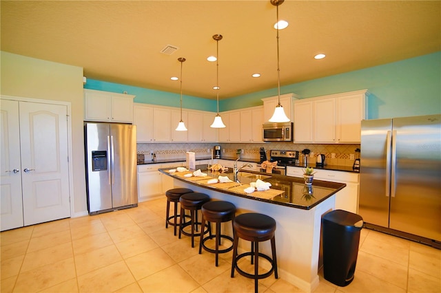 2147 Tripoli Ct, Kissimmee, FL 34747 - kitchen with appliances with stainless steel finishes, dark countertops, tasteful backsplash, decorative light fixtures, and light tile patterned floors