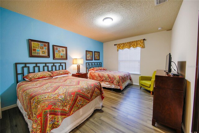 2147 Tripoli Ct, Kissimmee, FL 34747 - bedroom featuring a textured ceiling, wood finished floors, and baseboards