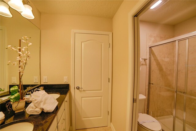2147 Tripoli Ct, Kissimmee, FL 34747 - full bathroom featuring a shower stall, double vanity, toilet, a textured ceiling, and tile patterned flooring