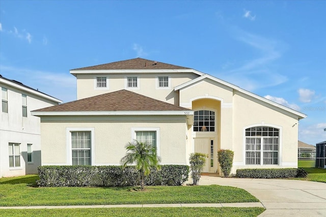 553 Bailey Cir, Davenport, FL 33897 - view of front of house with a front yard, a shingled roof, and stucco siding
