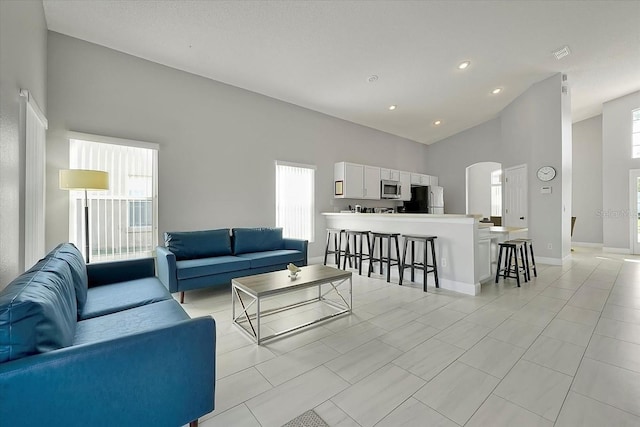 553 Bailey Cir, Davenport, FL 33897 - living area with arched walkways, healthy amount of natural light, high vaulted ceiling, baseboards, and recessed lighting