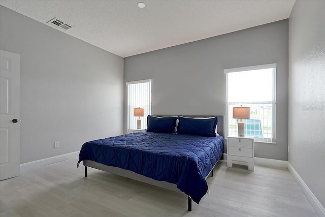 553 Bailey Cir, Davenport, FL 33897 - bedroom with light wood-type flooring, baseboards, and a textured ceiling