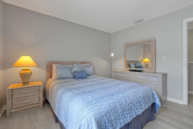 553 Bailey Cir, Davenport, FL 33897 - bedroom with light wood-type flooring, baseboards, and a textured ceiling