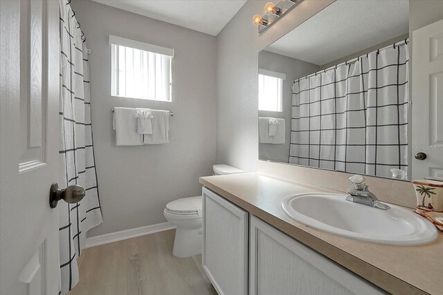 553 Bailey Cir, Davenport, FL 33897 - bathroom with plenty of natural light, vanity, toilet, and wood finished floors