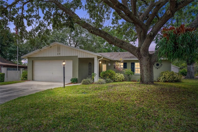 ranch-style house featuring stucco siding, an attached garage, a front lawn, and concrete driveway