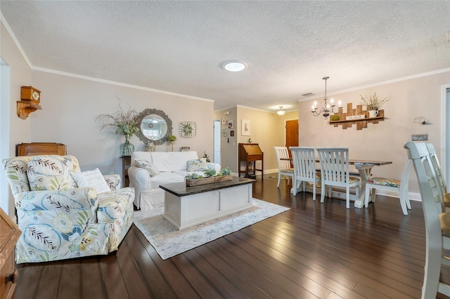living area featuring a textured ceiling, a chandelier, hardwood / wood-style flooring, crown molding, and baseboards