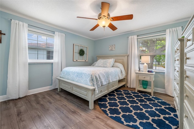 bedroom featuring wood finished floors, baseboards, a ceiling fan, and ornamental molding