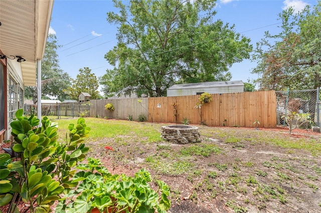 fenced backyard with an outdoor fire pit