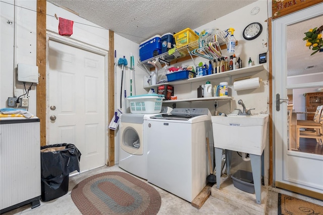 clothes washing area with washer and dryer and a textured ceiling