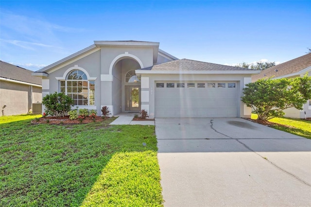 ranch-style home with stucco siding, a garage, concrete driveway, and a front yard