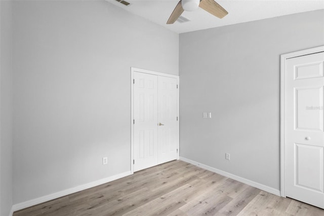 unfurnished bedroom featuring light wood-style floors, baseboards, a ceiling fan, and a closet